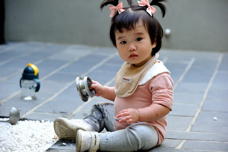 【長長的假期萬萬回來過第二個年！在前院花圃玩白石頭。】