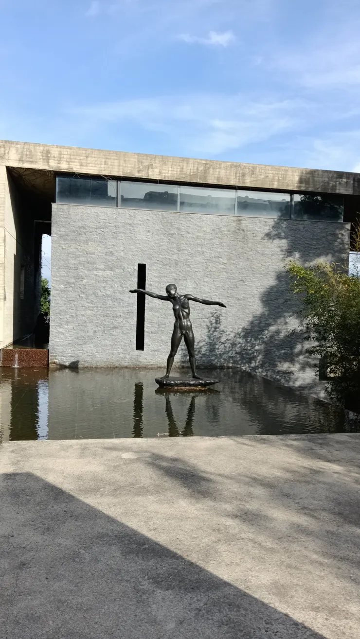 巨大高聳的建築為方正的清水模設計,散發著一股神秘氣息。入口為竹林小徑,穿越後抵達大門,映入眼簾的是灰階的水泥牆與一棵松樹,稍來了禪意。從大門進入後,便由專人帶領導覽,時間大約半小時,不能自行參觀。入口處放置的雕像,栩栩如生