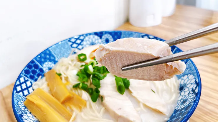 小白拉麵雞豚白湯拉麵特寫，碗內鋪滿大塊厚實的舒肥雞肉片，展現清爽低負擔的特色。