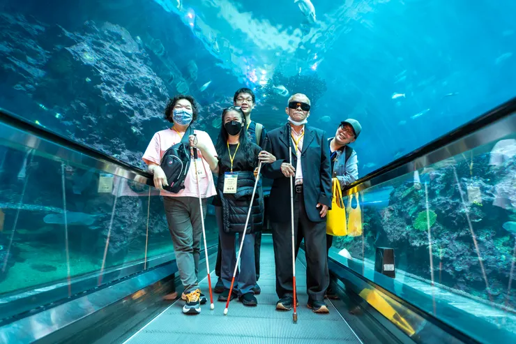 （圖說：視障朋友與社工蔡欣潔(左一)在海底隧道開心合影。）