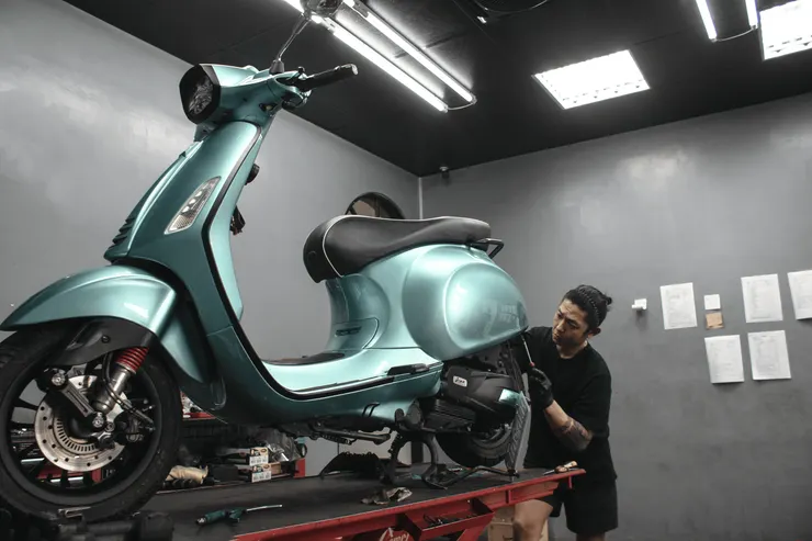 ▲Vespa 潮州店的技師正在裝修客人的機車。呂國維攝。