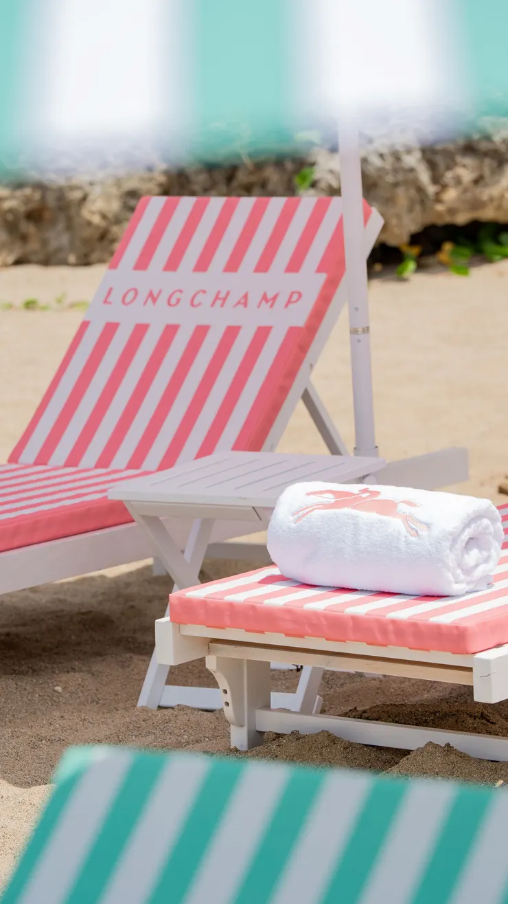 「LA PLAGE LONGCHAMP 瓏驤海灘俱樂部」以「經典奔馬」為核心視覺，搭配色彩繽紛的條紋躺椅、陽傘與海灘巾等元素，勾勒出輕鬆且富有節奏的夏日風格。圖／墾丁凱撒提供