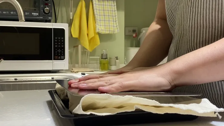 用廚房紙巾包住豆腐後壓上重物，放置一段時間等待豆腐出水