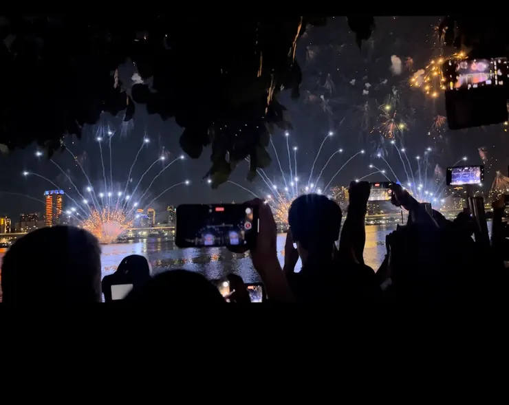 大樹旁剩下小小看得到煙火和河的畫面