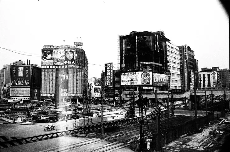 1980 年代之前，大臺北地區的電影院集中在中華商場附近的西門町。因應市民生活動線的變化，後來在臺北不同商圈也出現了電影院。 本照片拍攝於1985 年，當年鐵路還沒地下化，中華商場尚未拆除，遠方電影看板出現了《遠離非洲》，是勞勃．瑞福和梅莉．史翠普年輕時的代表作。（照片提供＝陳文宏，投入攝影超過三十年的金融業上班族）