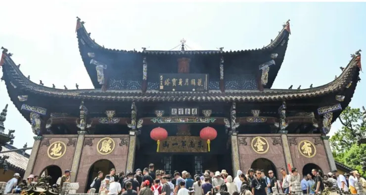 肉身宮的正面建築，雄偉的屋頂裝飾著精美的雕刻和顯眼的紅燈籠，前方擠滿了來訪的遊客，氣氛熱鬧非凡。