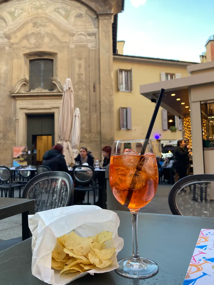 義大利的國民調酒Aperol Spritz和potato chips。平日的午後坐在路邊的酒吧喝，看起來很悠閒其實喝起來是苦的，或許就像義大利的生活吧。