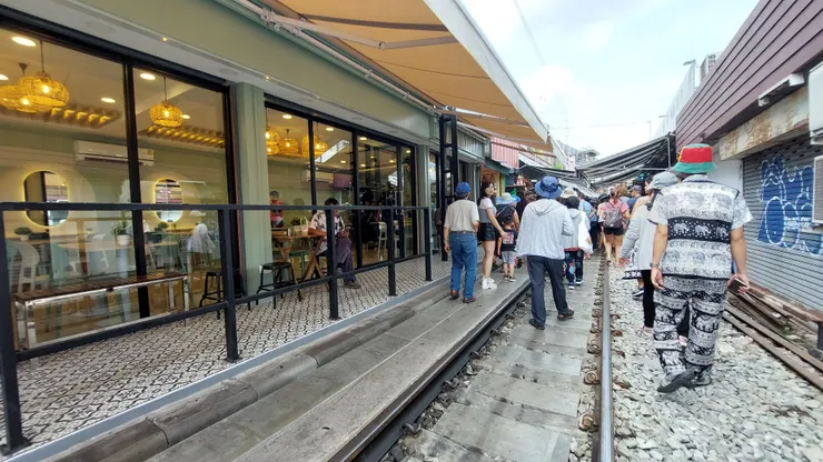 有的店面裝有大片玻璃窗，店裡賣飲料，讓客人可以邊喝飲料邊吹冷氣邊看火車