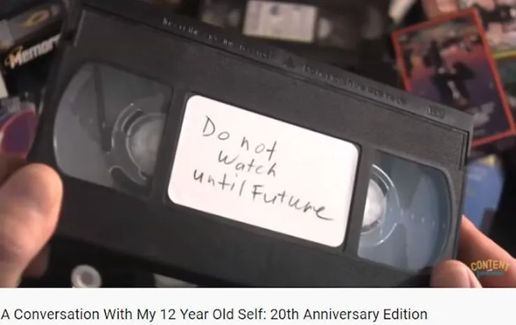 "未來還沒來之前，勿看!"  他手上的東西是錄～影～帶～