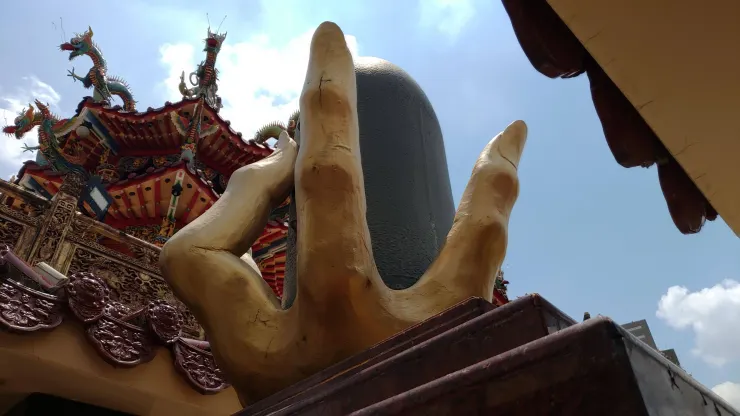  屏東萬丹萬惠宮廟埕右側的「媽祖接炸彈金手掌」紀念碑。 圖／廖英雁