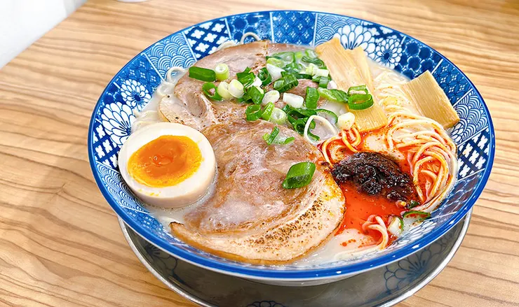 小白拉麵麻辣豚骨拉麵特寫，聚焦於湯頭上方的特製麻辣醬與豐富配料，東湖高CP值日式拉麵。