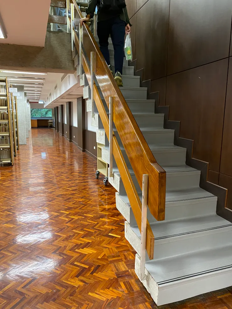 通往二樓書庫的樓梯，扶手使用溫潤的原木，支撐桿為鋁條