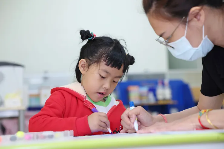 小禎與教保老師一起著色。