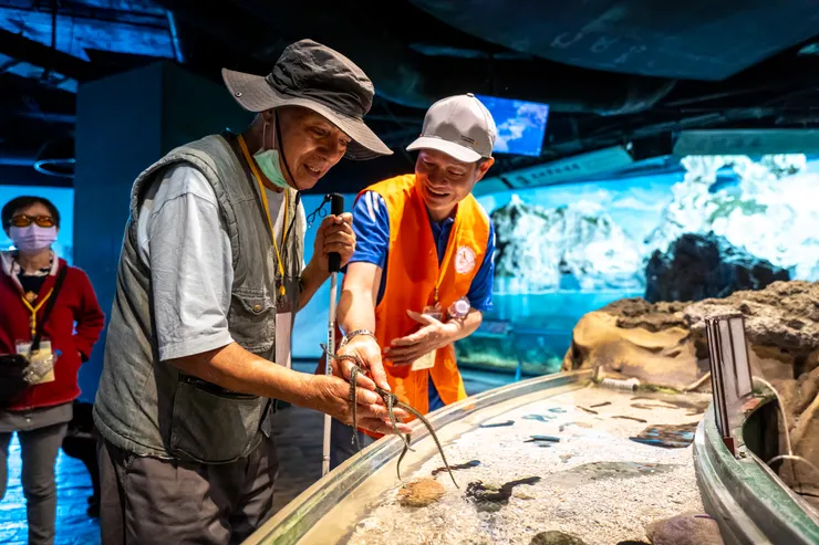 （圖說：蘇大哥在志工的引導下，嘗試觸摸海星。）