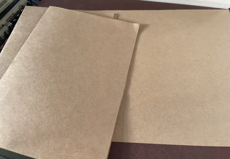 對半的A4牛皮紙和對半的A4牛皮紙對折的樣子。
