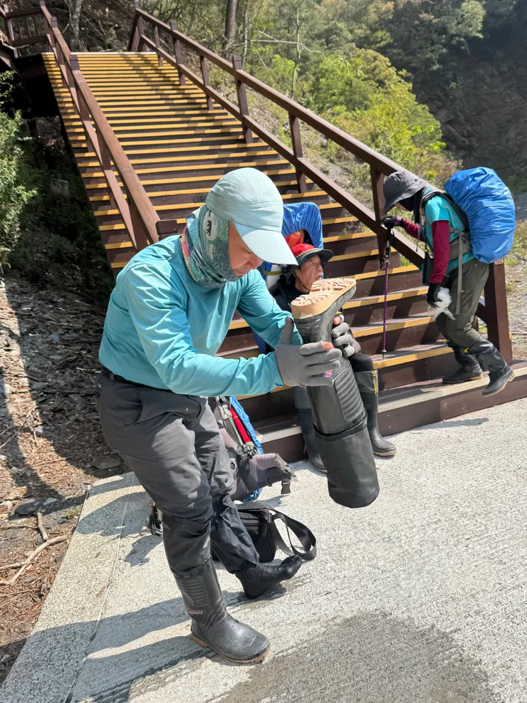 領隊倒出雨鞋中的奧萬大溪水。