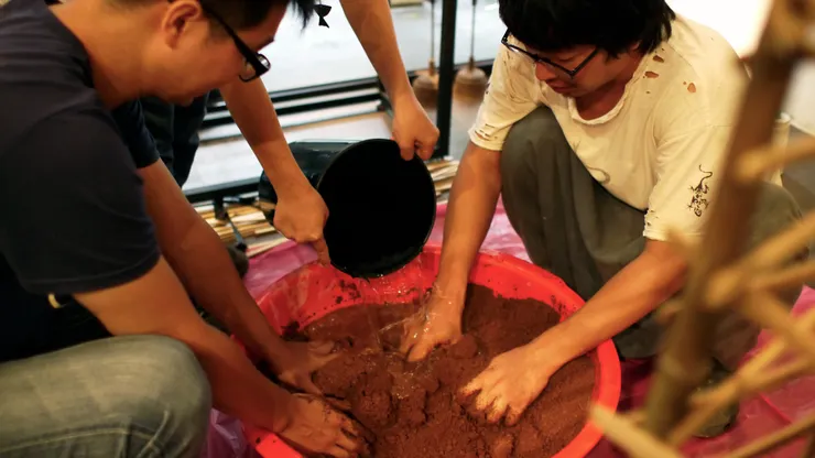 △展場的夯土展台從現場攪和泥土漿開始。