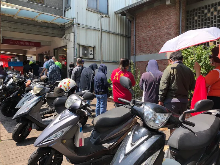 在艷陽下為新鮮春捲耐心等候的民衆