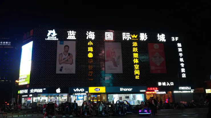 一邊是手搖飲的香氣，一邊是手機店的科技感，再配上NBA巨星廣告，三種場景自然交融，逛著逛著就停不下來，這樣的商業組合真的有點上癮。