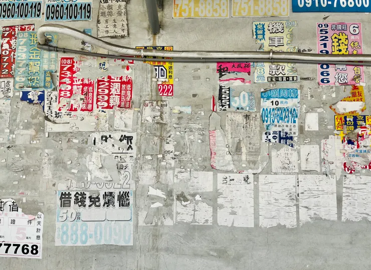 灰色的牆面上貼滿了各式廣告傳單