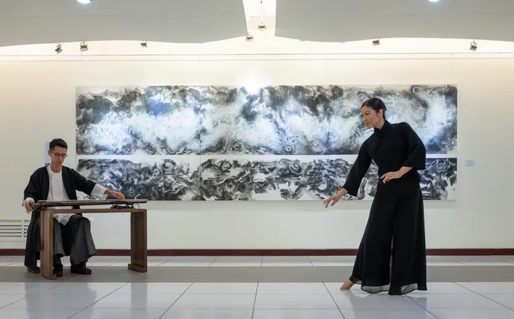 舞蹈家周章佞與古琴家陳濬寬在寬達五米的〈雲溪演算〉作品前展演