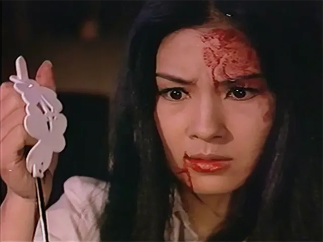 《神秘女郎白如霜》一鏡頭，讀者可留意陳慧美手握的兇器髮夾連結了前面《五瓣之樁》畫面中的髮簪。