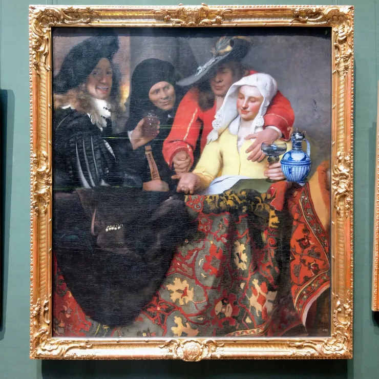 維梅爾的《老鴇》Bei der Kupplerin Vermeer, Johannes (1632-1675)： 這幅畫的很大一部分被一塊地毯佔據。其清晰可辨的圖案表明，這塊地毯來自安納托利亞西部小鎮烏沙克，那裡擁有悠久而豐富的地毯製作傳統。這幅畫作的地毯，因其深藍色的底色和中央紅色的洋蔥形圓形浮雕，可追溯至16世紀上半葉。東方地毯的藝術造詣備受推崇，在其他許多畫作中也能看到它的身影。維梅爾為我們呈現了一個寧靜平和的場景，其中的冒犯性並未立即顯現。然而，他毫不懷疑地表明了這是一幅拉皮條的場景：衣著時髦的追求者正在付款，而他的左手正撫摸著年輕女子的胸部。這雙忙著遞錢的手恰好位於構圖的中央，而畫面被欄桿的上緣水平地分成兩半，這絕非巧合。－引自網路