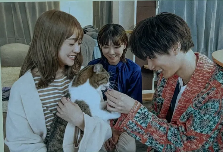 同住的三人與貓咪三日月，照片翻拍於慈善首映場A4海報。