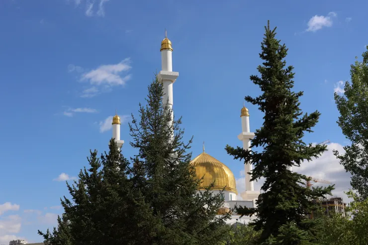 前往努爾阿斯塔納清真寺，金色圓頂和宣禮塔已從樹梢間悄悄探頭。