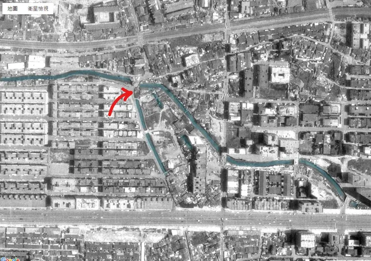 1974年航照圖，剛通車的忠孝東路上，可見蜿蜒的大灣河流；紅色箭頭是安東街水門位置。