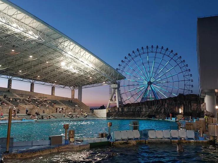 從側邊拍名古屋水族館的海豚及虎鯨表演場地，這樣同時拍到表演台和名古屋港的摩天輪真的很漂亮~照片右邊就是大銀幕，而面對銀幕的大型露天台就是觀眾座位，位置算是非常多，但如果太晚來就得坐很後面了~