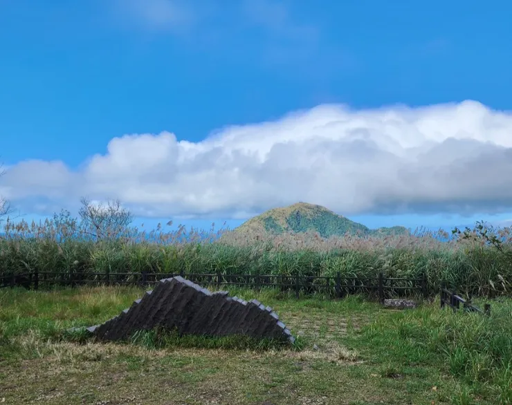 由於取景的角度，前景的小山似乎不小於背後的基隆山，該山在雲霧繚繞中頗有富士山的架勢。