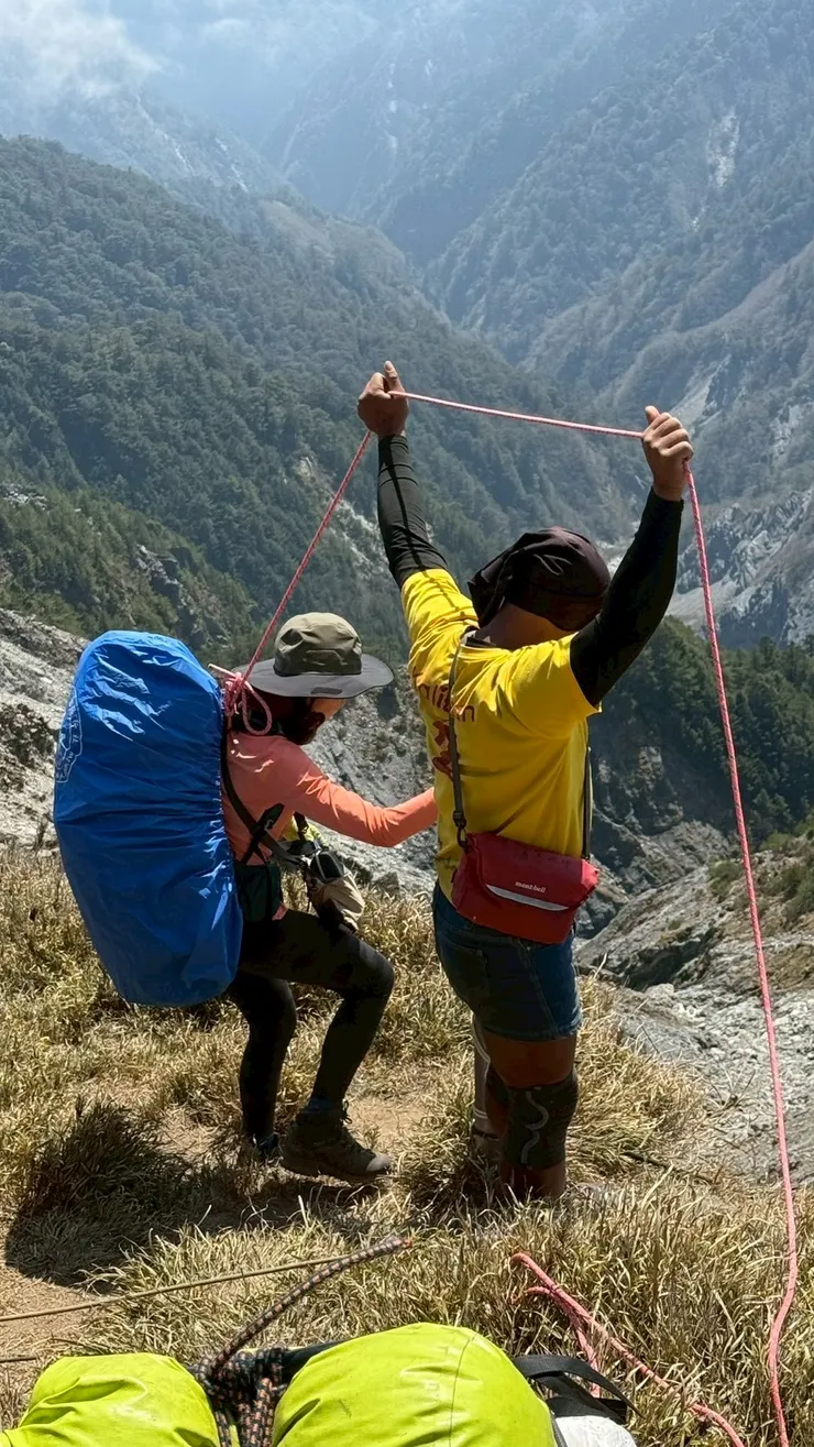 協作以繩索確保我下崩壁。