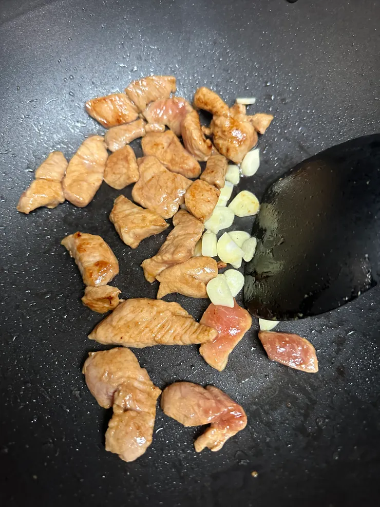 肉稍微變白後加入蒜片炒至聞到香味