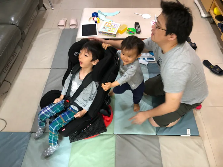 即使生理有礙，也值得非常豐富多元的人生。父子三人一起玩自製旋轉盤。