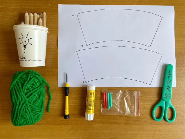 材料為紙杯２個、毛線、小段吸管和線稿；工具則有彩繪用筆、剪刀、口紅膠及戳洞用尖頭小工具。