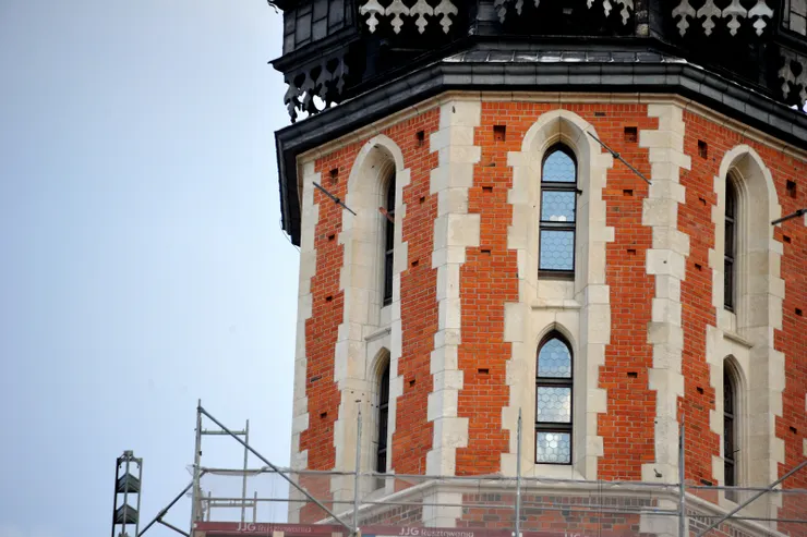 【整點號角響起眾人仰瞻聖母聖殿！由於小號手不會固定在某扇窗前吹奏，位置又高，循聲找人並不容易，我只捕捉到他吹完後向塔下遊人致意揮出的手(左上窗戶)。】