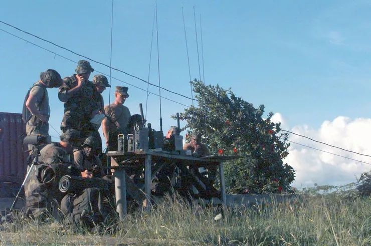 ANGLICO兼具FAC和火砲觀察員的職能，為部隊協調引導航空與火炮支援，能乘坐軍機或以地面小隊的方式執勤。而其特殊之處在於ANGLICO負責的是在跨軍種或跨國籍聯合行動中，為與海軍陸戰隊相鄰的盟國與其他軍種提供引導與協調，桌上的無線電與雷射指示器就是他們最強大的武器(注意此圖中出現的雷射指示器是90年代末服役的AN/PEQ-1而非波斯灣戰爭期間使用的AN/PAQ-3)。ANGLICO最小也最常見的單位是火力控制小組（FCT），由具備聯合終端攻擊管制員資質的上尉指揮2-3名負責無線電或前沿偵查的陸戰隊；而在此戰中，邊境的FCT又進一步拆分成2個小組輪流在邊境值勤。兩個FCT加上一個8人指揮組組成一個支援武器聯絡隊(SALT)，指揮組和營級單位合作管理運作旗下的FCT。