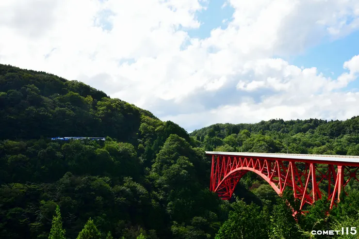 火車從三井野大橋旁的山腰上緩慢通過