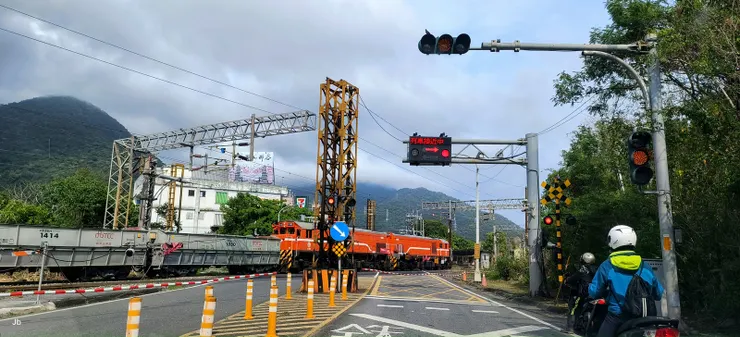 【離開DAKA,前往東澳的粉鳥林漁港阿滿姨小吃部午餐。去電詢問,說是3點前趕到都還出餐。途中等候平交道紅燈,一輛台泥水泥列車正經過。】