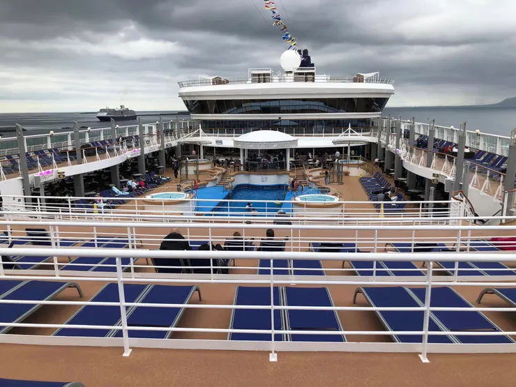 中間藍色區域是泳池，四周有躺椅，但只有兩三個人游泳，躺椅上幾乎沒人，但可想像夏天時的盛況。