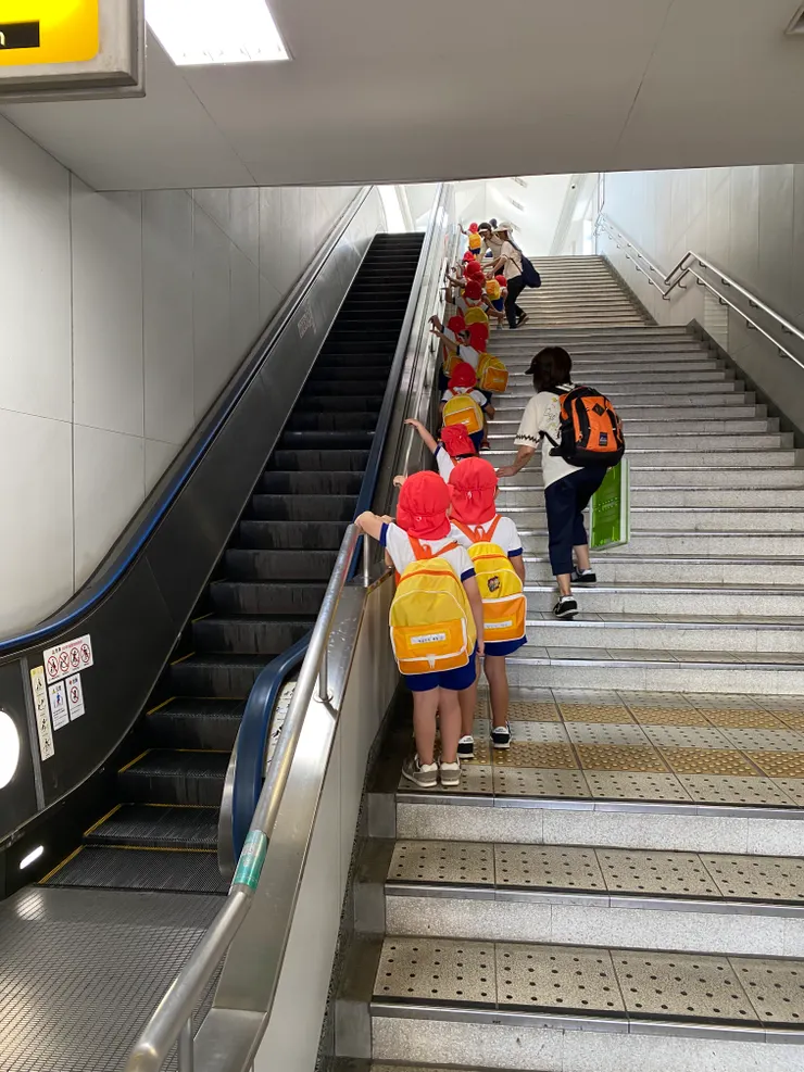 看到幼稚園的孩子們魚貫爬樓梯準備搭車