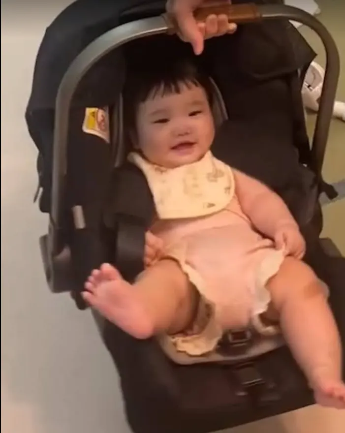 在客廳用嬰兒提籃玩耍