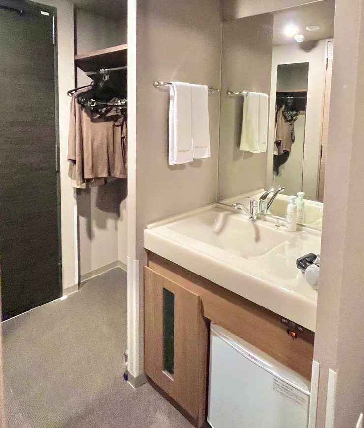 玄關處的開放式衣櫃、全身鏡和洗手台