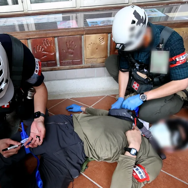 遭病患持爆裂物攻擊、遭炸傷的醫療組成員，被判定為右手斷肢、右大腿大量出血，由組員緊急救治中