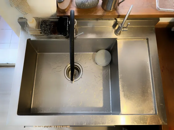 特別訂製的不鏽鋼洗手槽，因應時常忘記關過濾水的困擾，同時也可以作為備料的檯面。