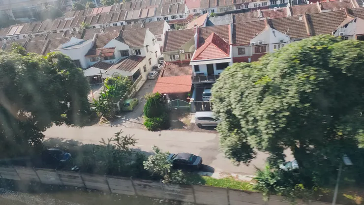 從大眾運輸工具的高架橋往下看，可以看到整齊的住宅區和分隔道路的圍籬。