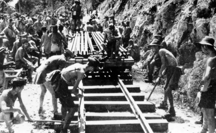 澳洲戰俘在烈日下辛勤工作，鋪設鐵軌。疾病、惡劣的工作條件，更不用說日軍的殘暴而導致數千人喪生，此時盟軍戰機頻繁轟炸鐵路，造成更多傷亡。