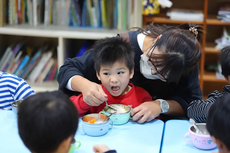 （圖說：伊甸鳳山早療中心教保員秦瑩引導慢飛天使學習用湯匙進食。）