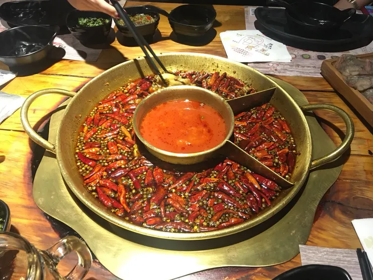 哥老官重慶美蛙火鍋，牛蛙鮮嫩到像蒜香雞腿肉。 麻辣湯底越煮越香，熱門時段排隊三小時，年輕人依舊甘願等。